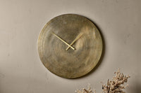 Okota antique brass wall clock hung on a neutral wall