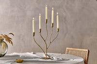 Palani antique brass candelabra with lit taper candles on a table