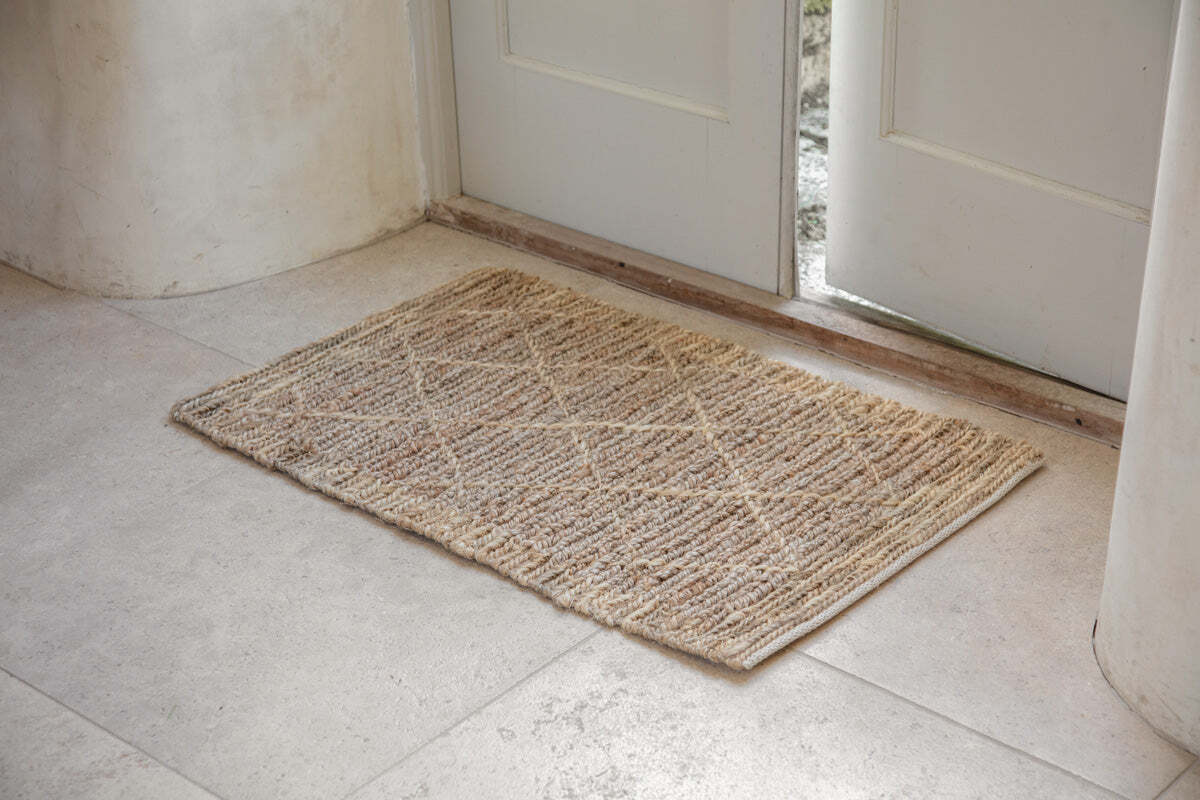 Vandi natural jute doormat placed inside a doorway