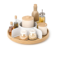Umbra Bellwood Lazy Susan in white and natural wood filled with oils and spice jars on a white background