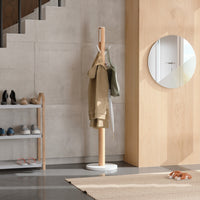 Umbra Flapper coat rack styled in a hallway holding a coat and bag